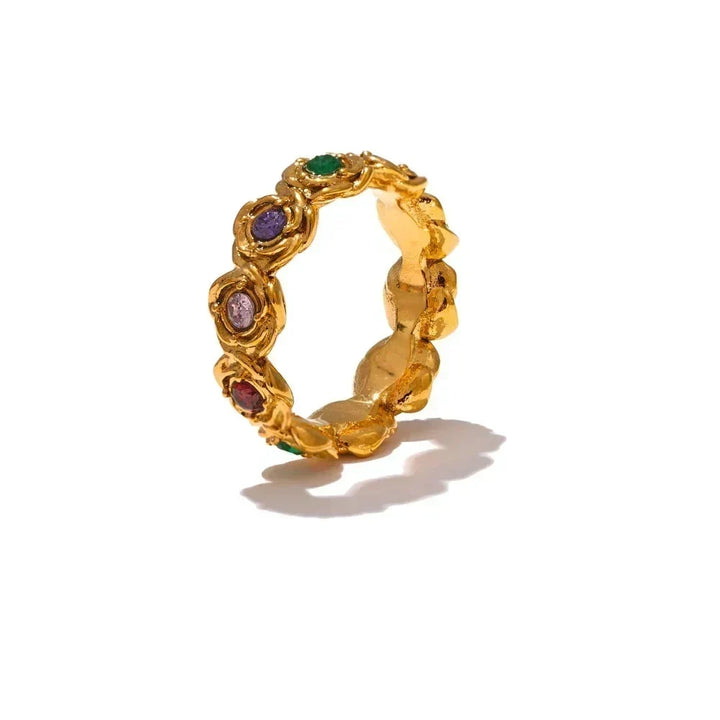 Gold ring with colorful gemstones on a white background