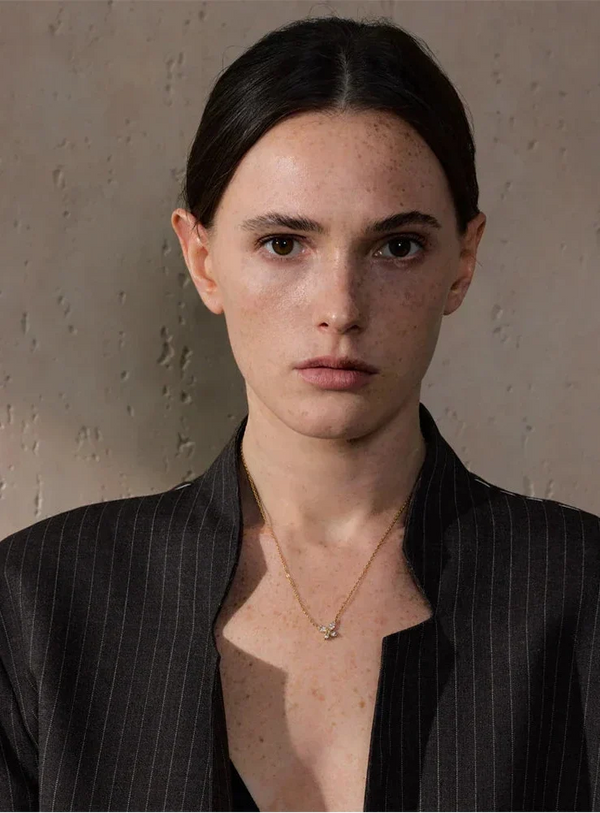 Woman wearing a black pinstripe blazer against a neutral background