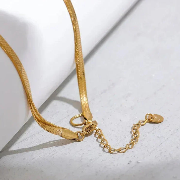 18K gold-plated flat chain necklace with adjustable clasp on light surface