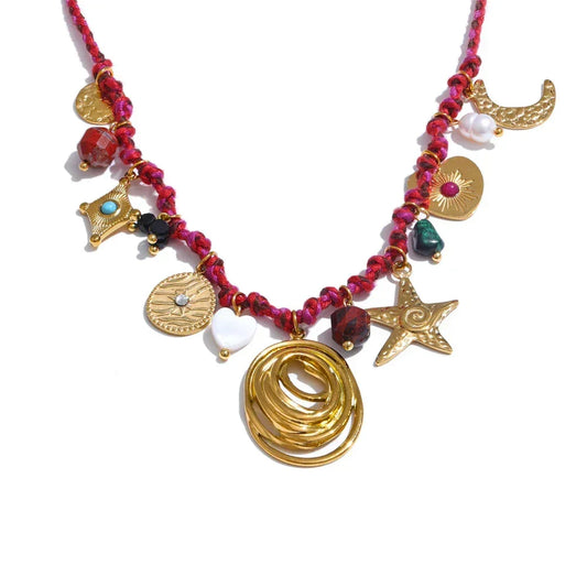 Necklace with gold charms and red beads on a white background.
