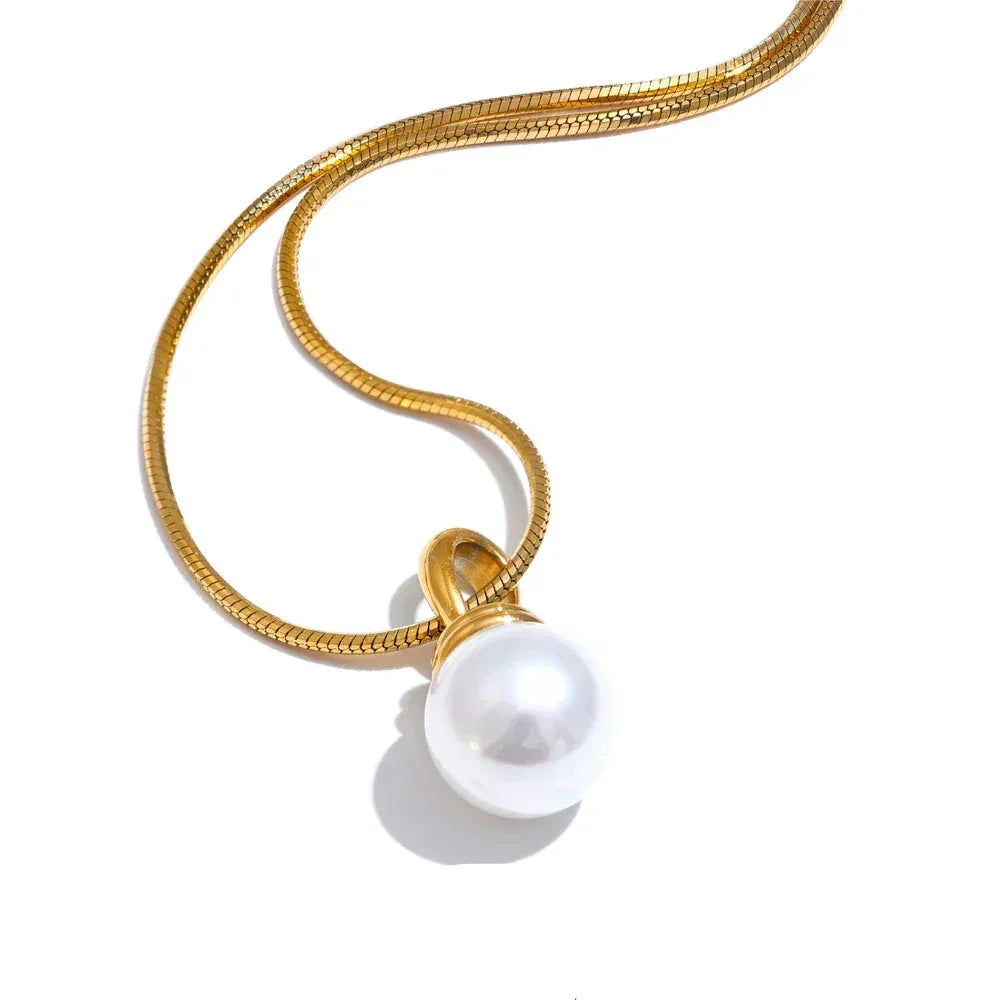 Gold necklace with a pearl pendant on a white background.