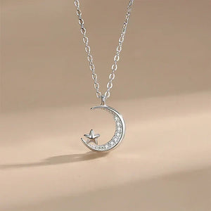 Silver necklace with a crescent moon and star pendant on a beige background-Moonlit Star Pendant - TM & Co. Jewels.