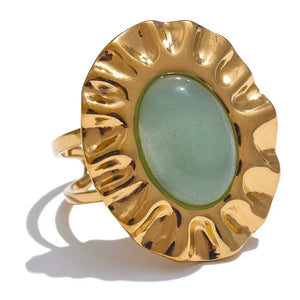 Gold ring with a green stone on a white background
