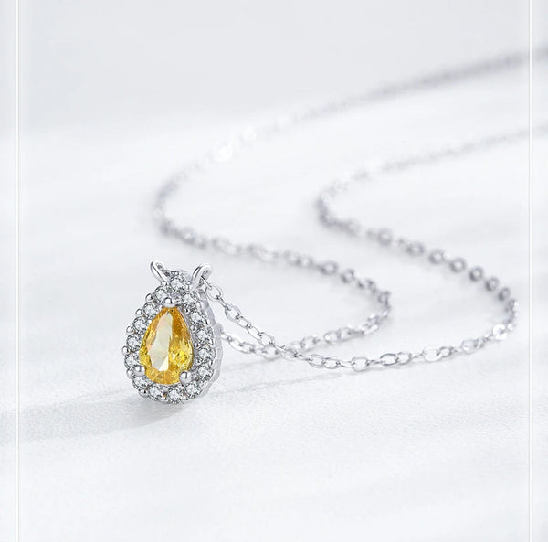 A silver-tone pendant necklace with a teardrop-shaped yellow gemstone surrounded by small clear stones, displayed on a light gray background with the text 'Original Jewelry' at the top.