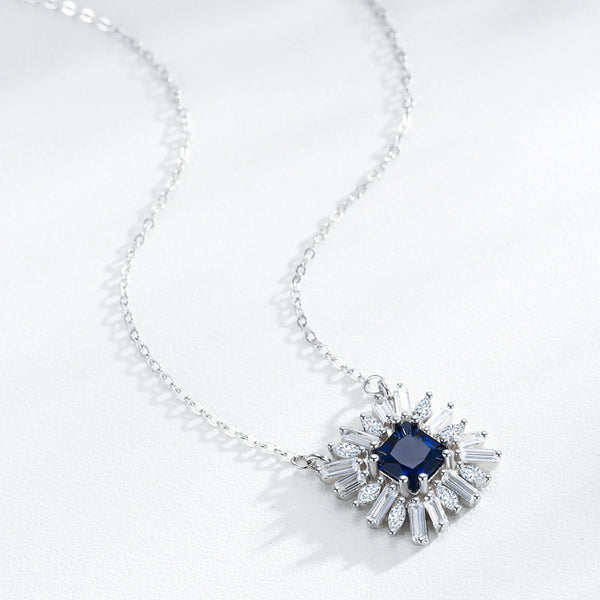 Necklace with a blue gemstone and diamond-like stones on a white background