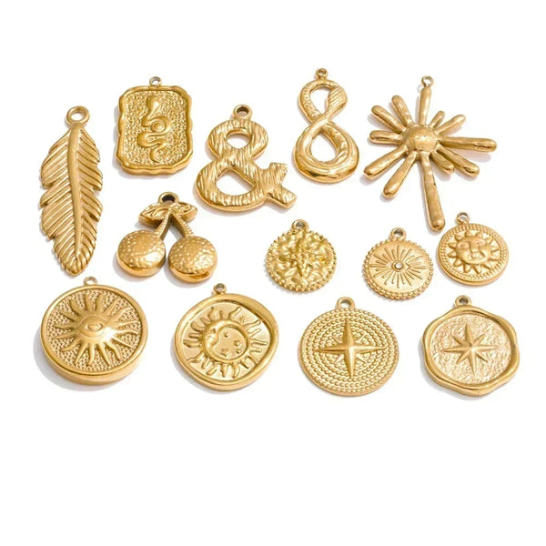 Collection of gold jewelry pendants on a white background.