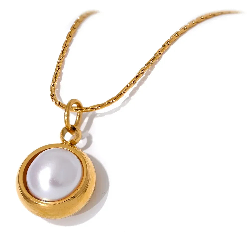 Gold necklace with a pearl pendant on a white background.