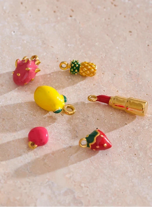 Colorful fruit-shaped charms on a textured beige surface