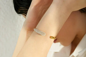 Gold bracelet on a wrist with a blurred background