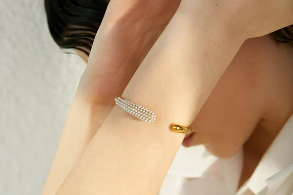 Gold bracelet on a wrist with a blurred background