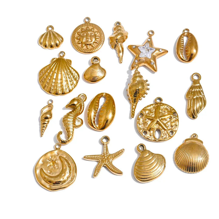 Collection of gold seashell and beach-themed jewelry pendants on a white background.
