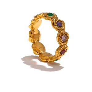 Gold ring with colorful gemstones on a white background.