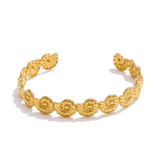 Gold bracelet with floral patterns on a white background