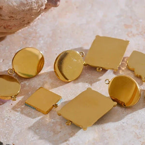 Gold jewelry pieces on a textured surface