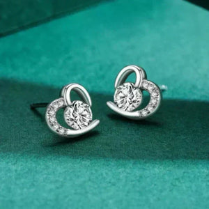 Silver earrings with circular design on a green background