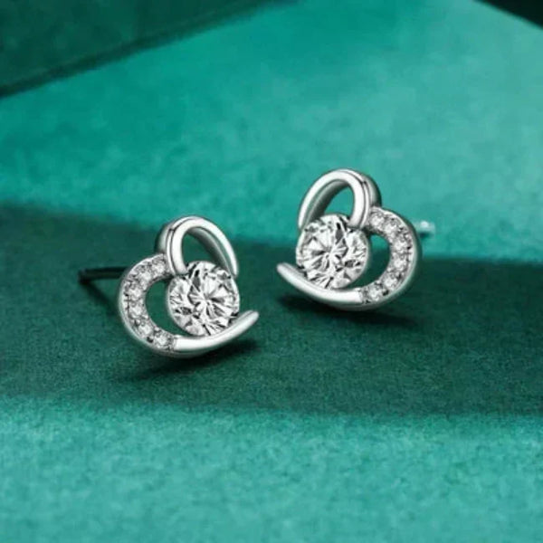 Silver earrings with circular design on a green background