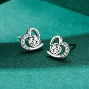 Silver earrings with circular design on a teal background
