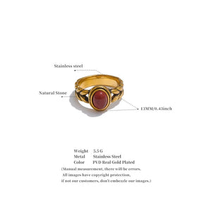 Gold ring with a natural stone on a white background