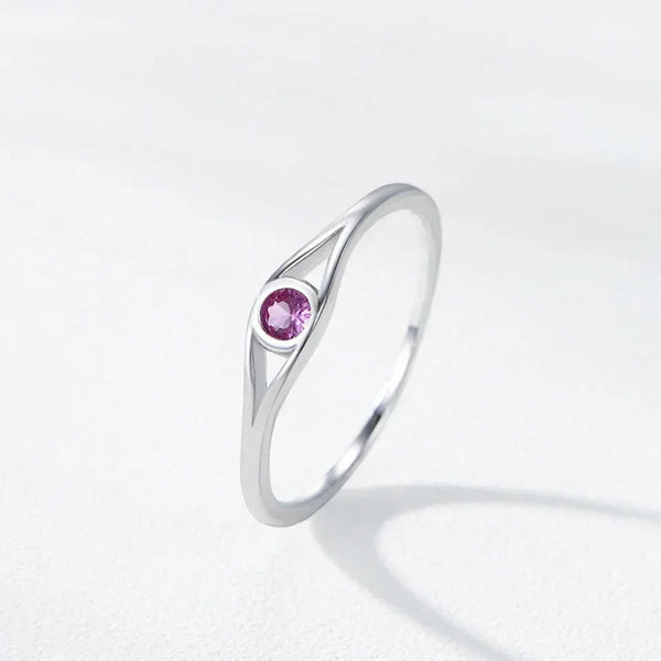 Silver ring with a pink gemstone on a light gray background