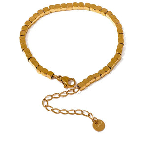 Gold beaded bracelet with a clasp on a white background.