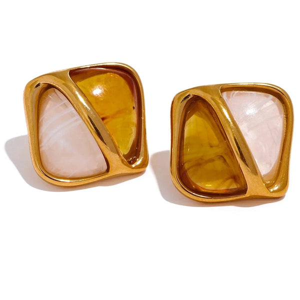 Gold-framed earrings with amber and beige stones on a white background.