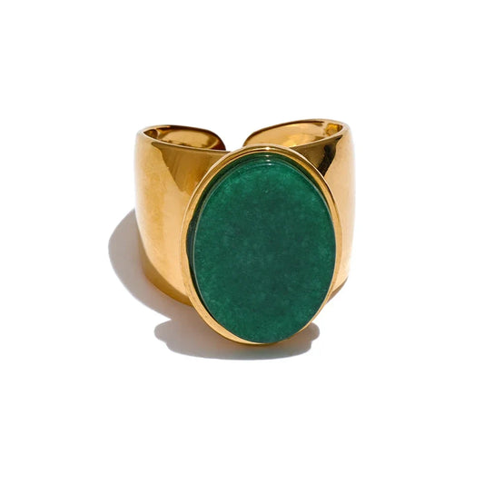 Gold ring with a green stone on a white background
