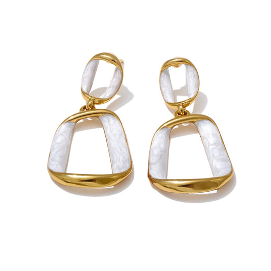Gold and white earrings on a white background