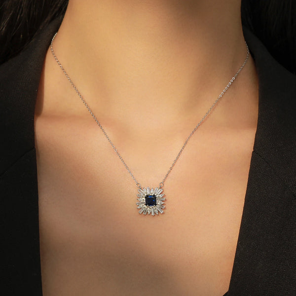 Necklace with a blue gemstone pendant on a person wearing a black top.