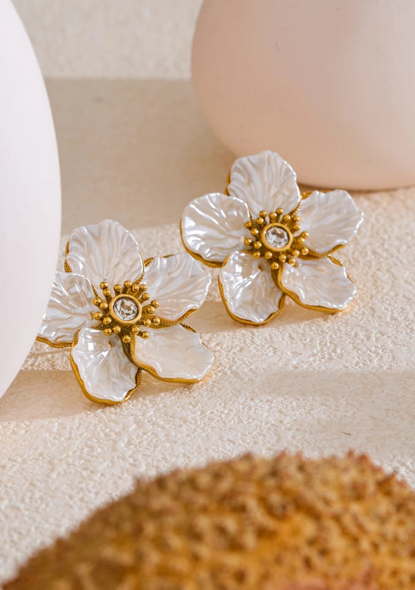 Floral earrings with gold accents on a textured surface