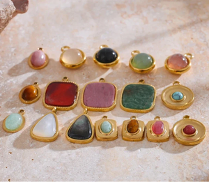 Collection of colorful gemstone pendants on a textured surface