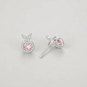 Pair of silver earrings with pink gemstones on a light gray background