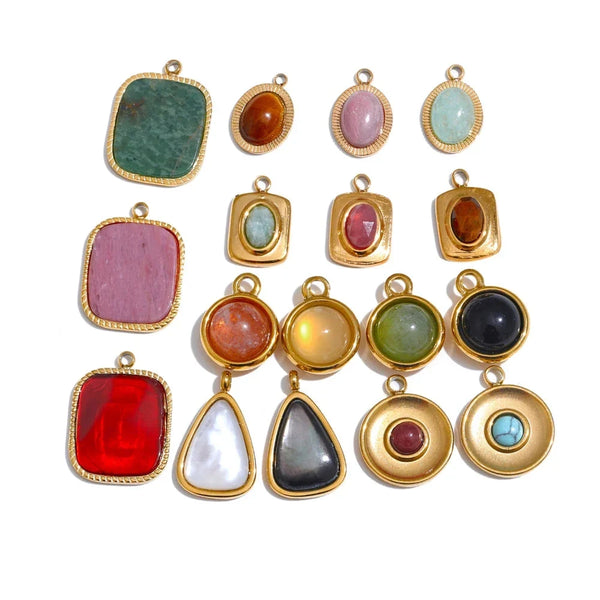 Collection of colorful gemstone pendants with gold frames on a white background.