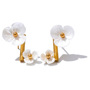 Pair of white flower earrings with gold centers on a white background