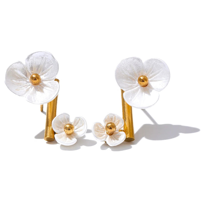Pair of white flower earrings with gold centers on a white background