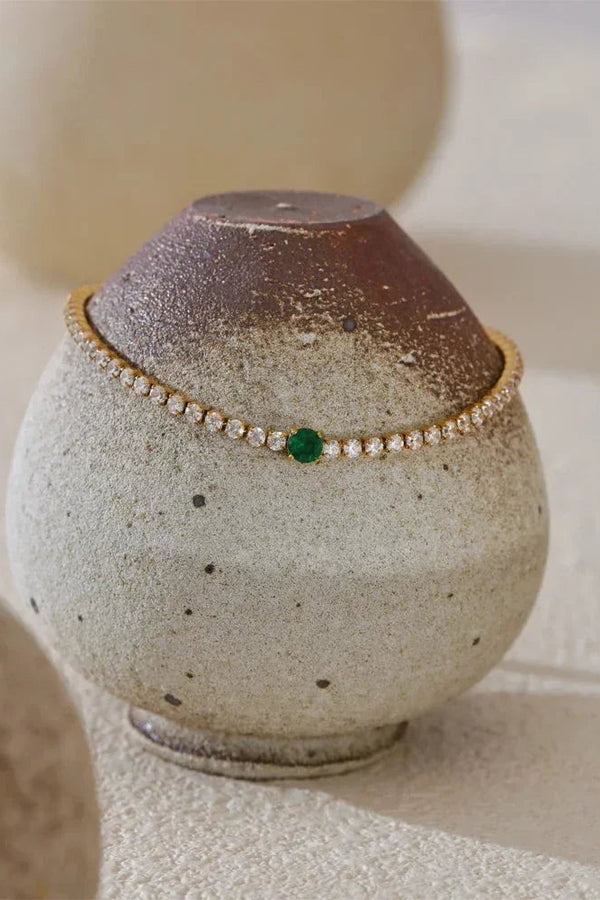 Jewelry box with a bracelet on top against a neutral background