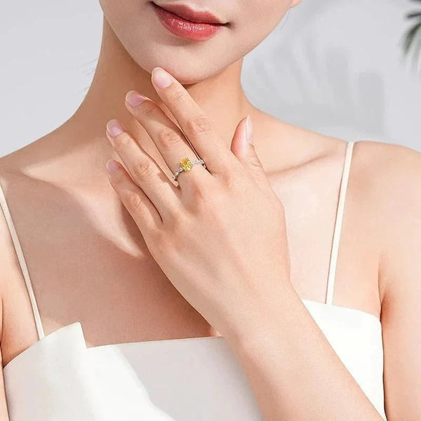 Woman wearing Amber Luxe Engagement Ring - TM & CO. JEWELS - Ring with a yellow gemstone and diamond accents on a white background.