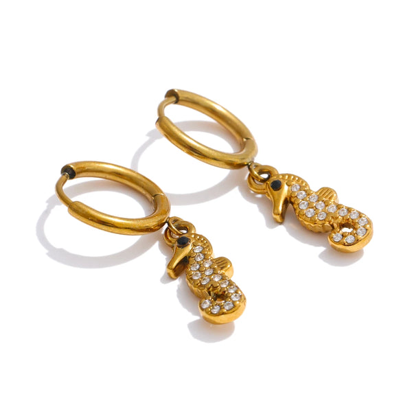 Gold earrings with seahorse charms on a white background