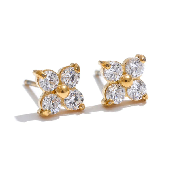 Gold and crystal flower-shaped earrings on a white background.