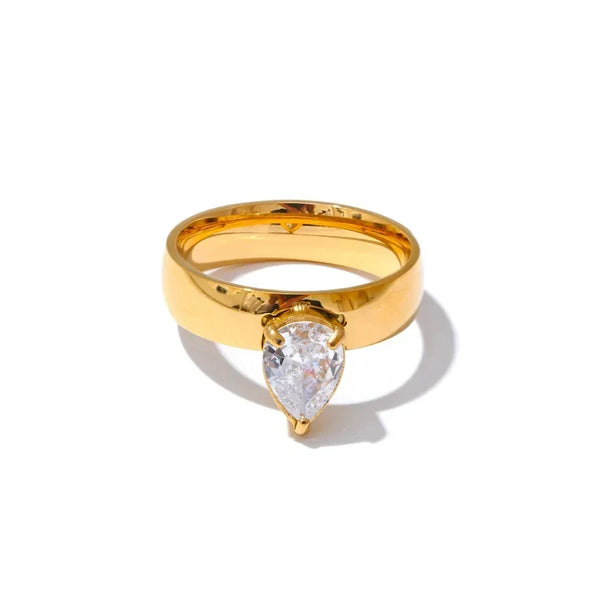 Gold ring with a pear-shaped diamond on a white background
