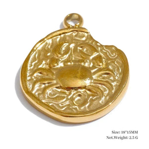 Gold pendant with intricate design on a white background