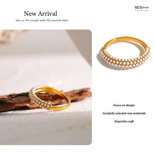 Gold-plated ring with rows of small pearls on textured beige fabric background