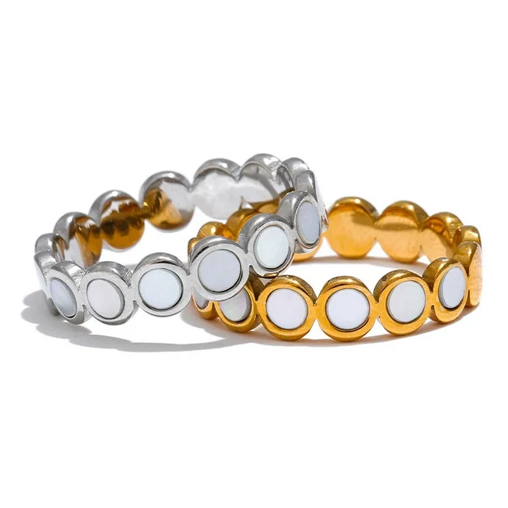 Three bracelets in gold, silver, and white on a white background
