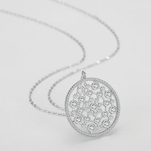 Silver necklace with a detailed pendant on a light gray background