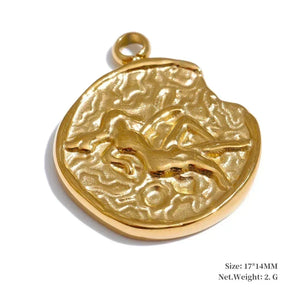 Gold pendant with engraved design on a white background