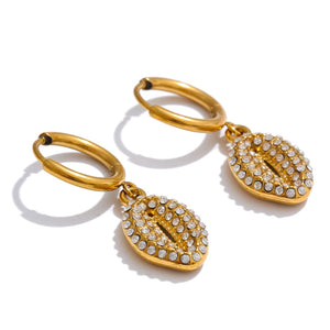 Gold hoop earrings with leaf-shaped pendants on a white background