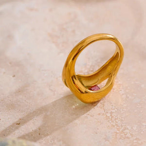 Gold ring on a textured beige surface