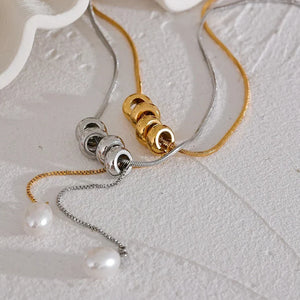 Jewelry with gold and silver chains on a textured surface