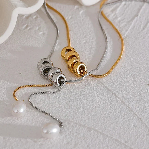 Jewelry with gold and silver chains on a textured surface
