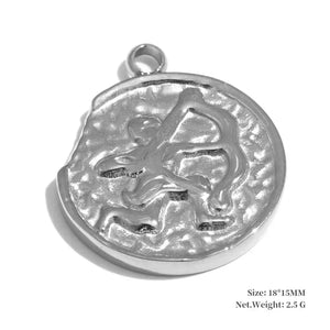 Silver pendant with engraved design on a white background