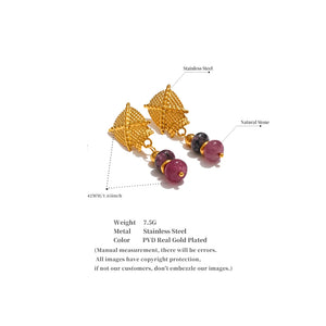Gold earrings with natural stones on a white background
